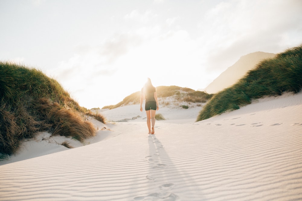 woman walking on beach sand