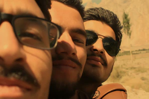 Casual outdoor scene with friends wearing Caserne sunglasses, laughing near a mountain view.