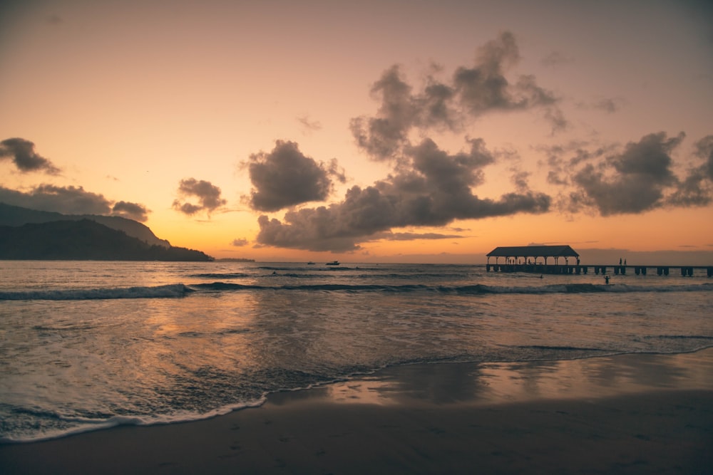 photographie de paysage de plage de sable blanc pendant l’heure dorée