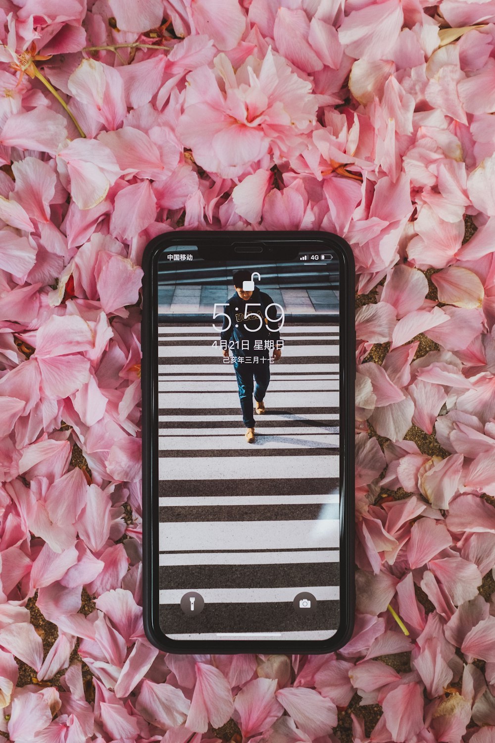 a cell phone laying on a bed of pink flowers
