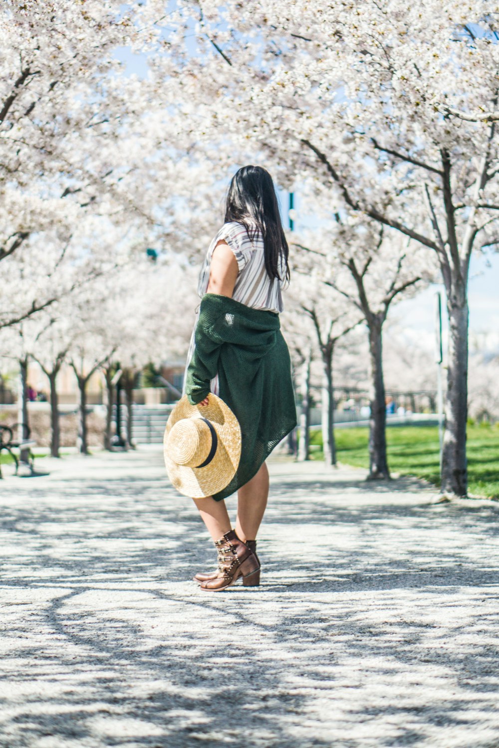 Femme debout sous des arbres à fleurs blanches