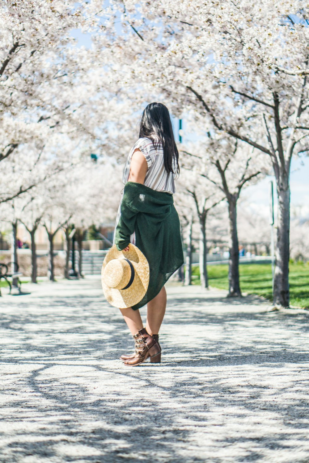 Mujer de pie bajo árboles de flores blancas