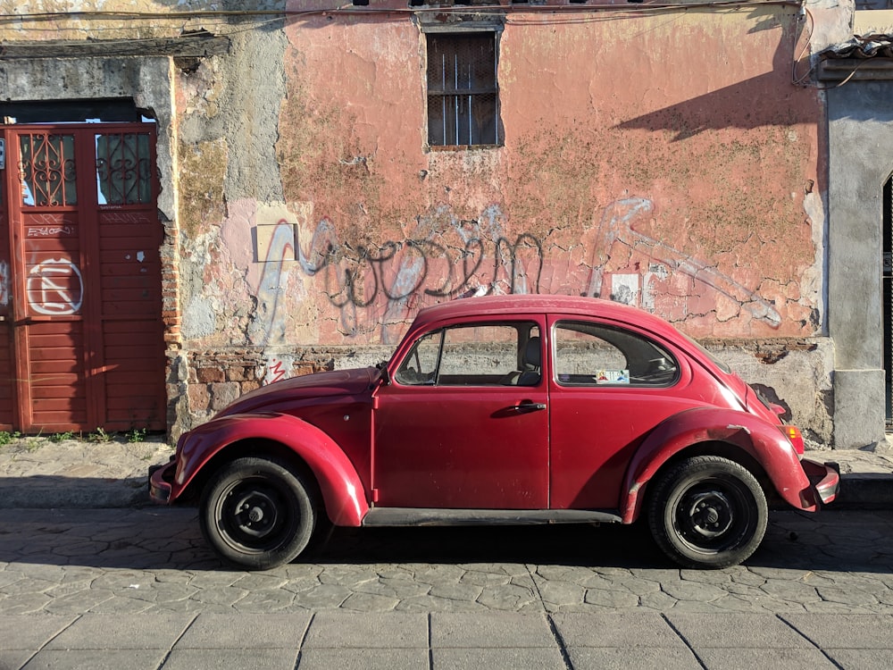 red Volkswagen Beetle coupe parked during daytime