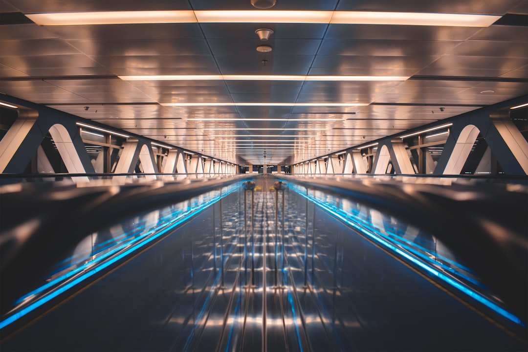a very long and empty walkway with blue lights,