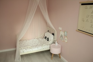 Cozy children's bedroom with playful wall decals and soft pastel bedding.