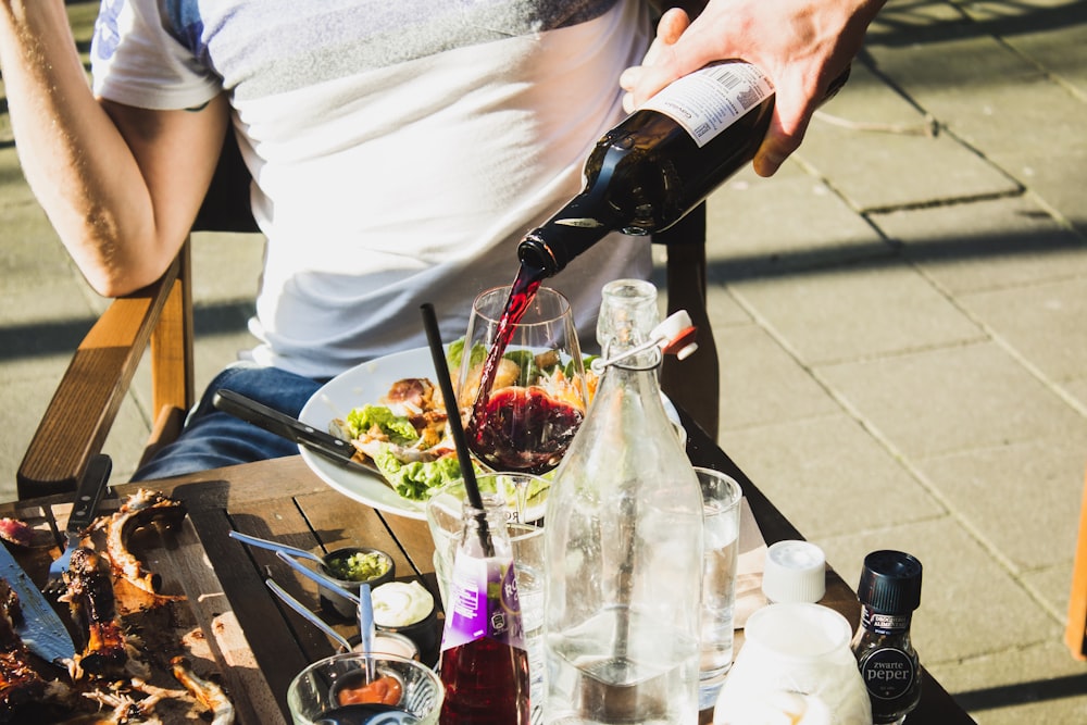 Mann sitzt beim Einschenken von Wein