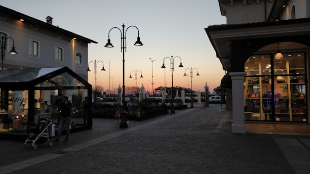 A cozy downtown Naperville street scene at sunset with glowing shop windows.