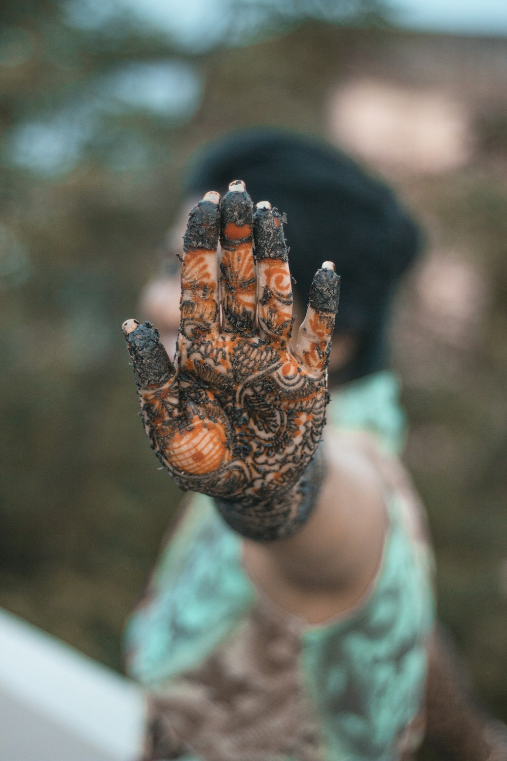 woman showing black and orange mehndi art