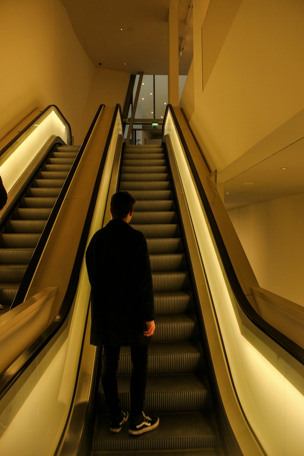 man standing on escalator