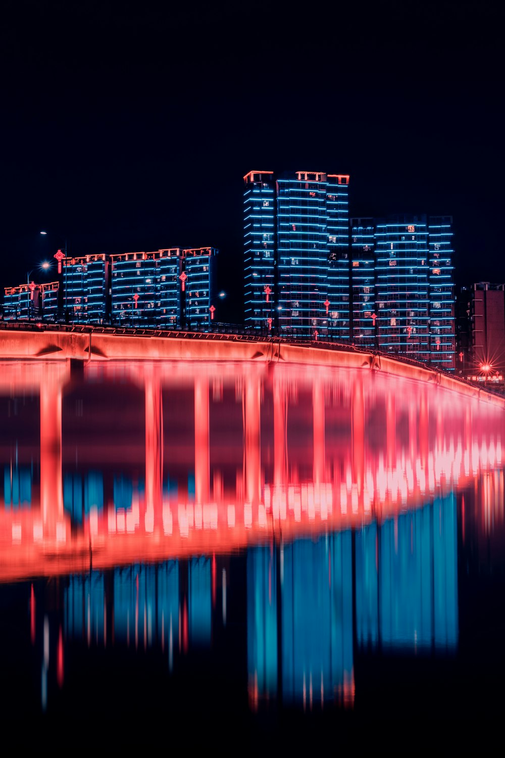 a bridge that is lit up in red and blue