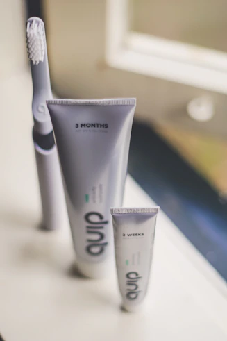 A bright bathroom shelf displaying mouthwash, oral sprays, and dental floss in sleek packaging.