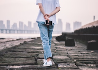 person wearing jeans and holding phone
