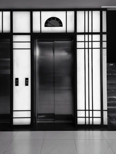 Technician installing a modern elevator control panel in a building.