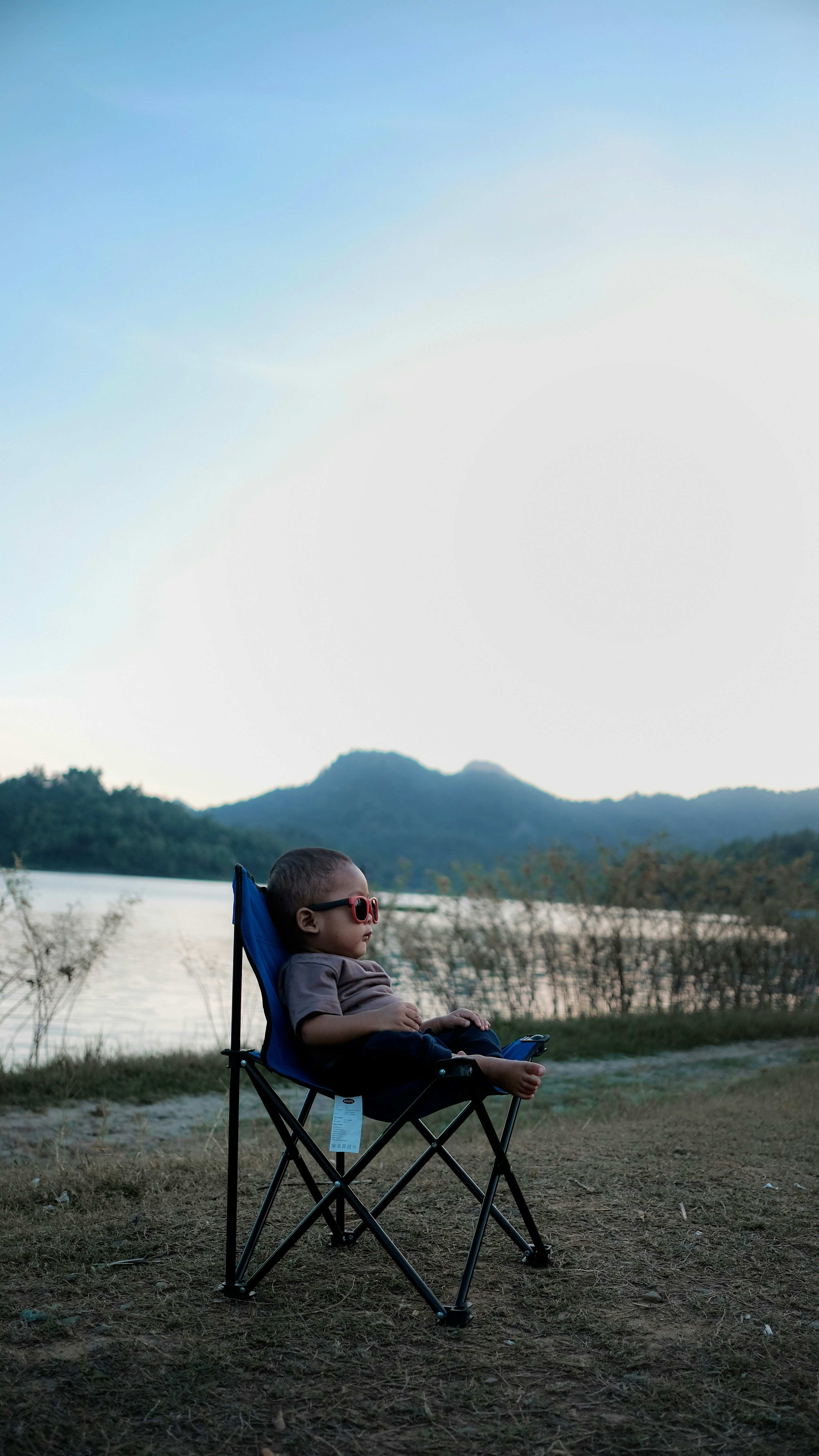 toddler's sitting on black and blue camping chair