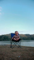 boy sitting on blue camping chair photography