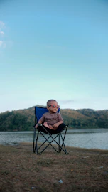 boy sitting on blue camping chair photography