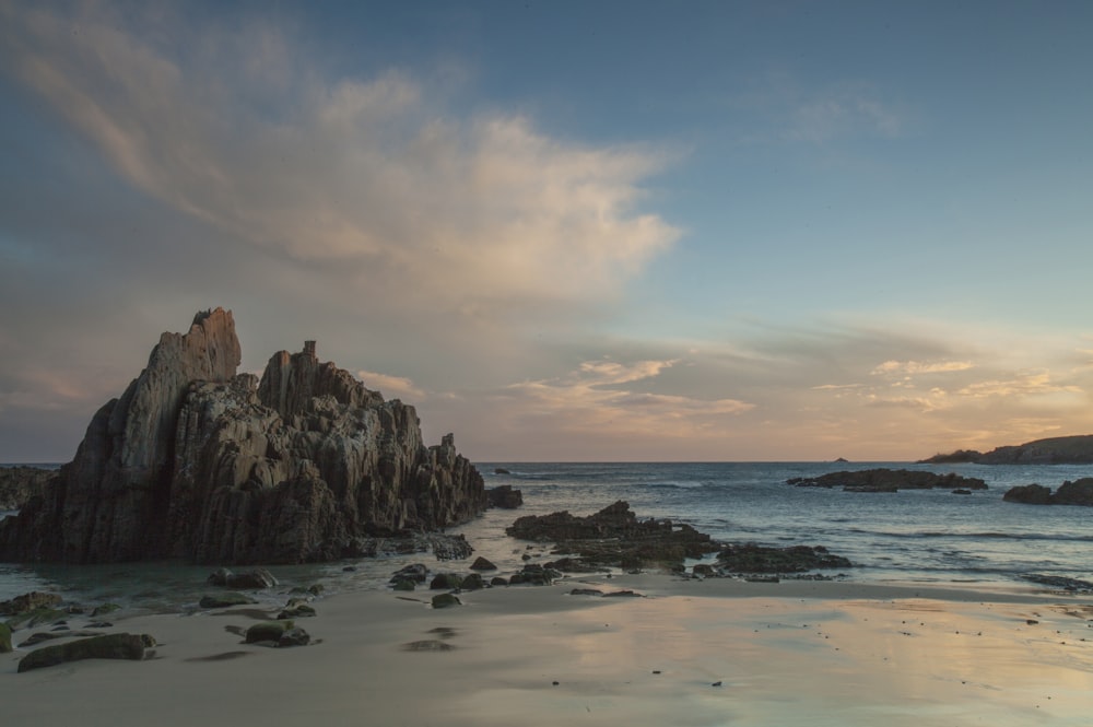 rocks by the sea under blue sky and white clouds