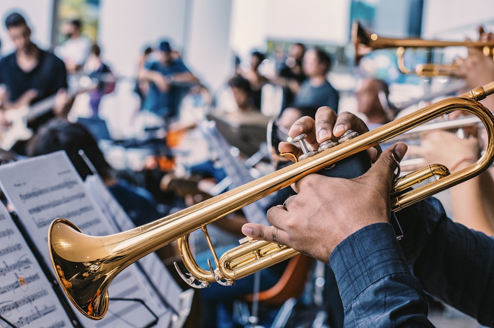 person playing gold trumpet