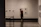 Close-up of a man admiring a framed artwork on a gallery wall.