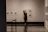 Close-up of a man admiring a framed artwork on a gallery wall.