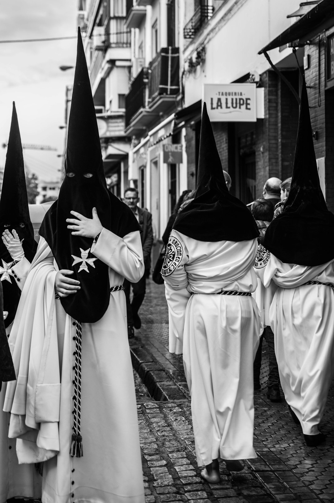 four people wearing black head masks