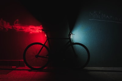 暗闇に赤と青で照らされた自転車の画像
