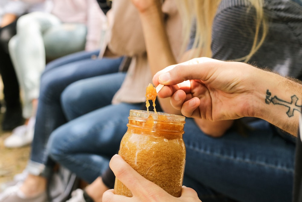 personne tenant un pot de confiture