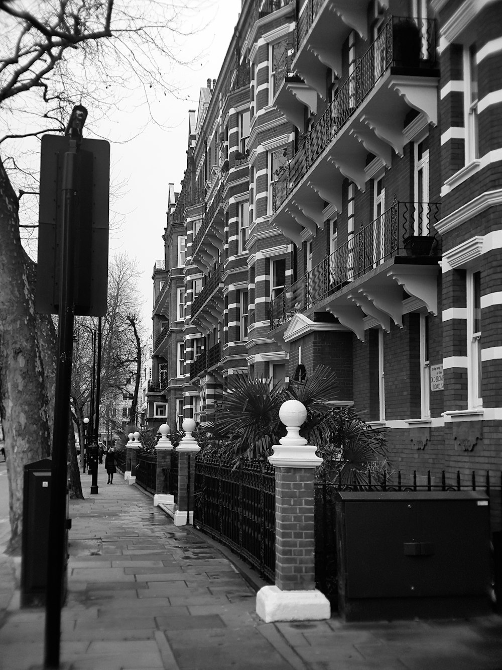 grayscale photography of sidewalk beside building