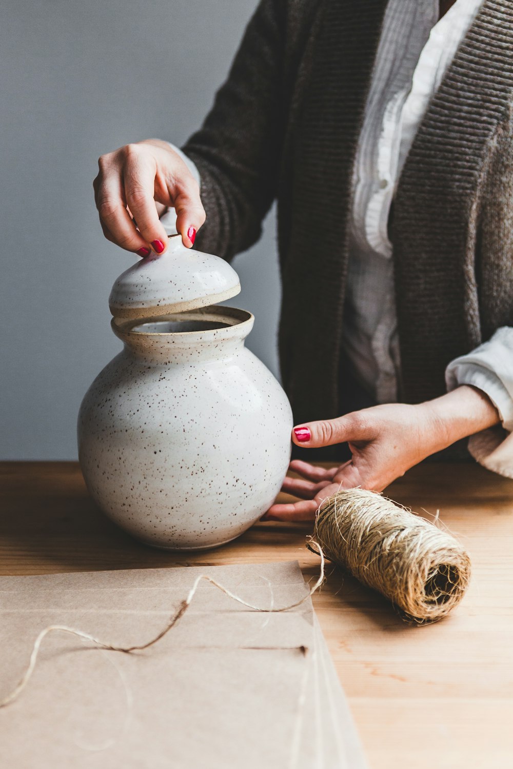 gray ceramic jar with lid and brown thread