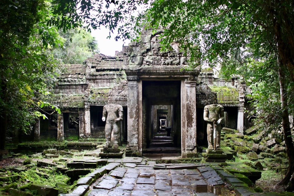 two grey stone statues on both sides of building entrance