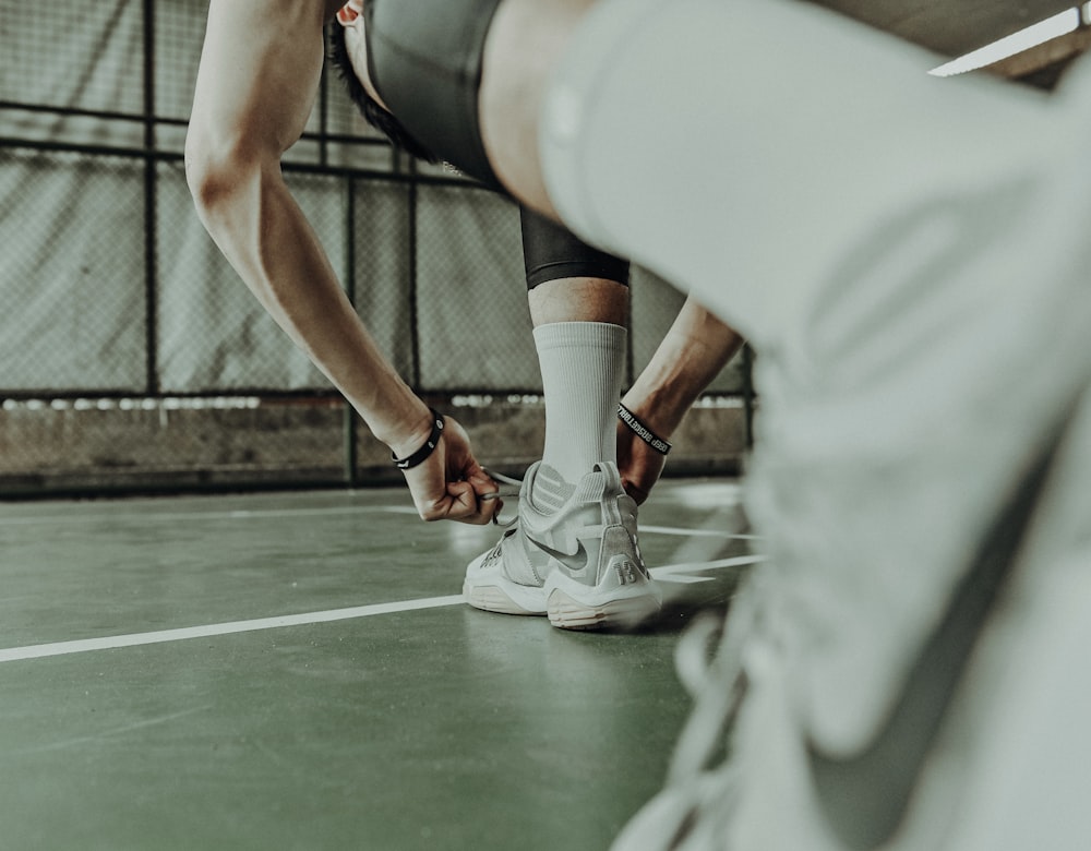 persona che indossa scarpe da ginnastica Nike bianche