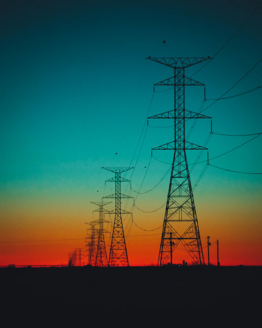 Transmission tower silhouetted against a dark sky