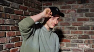 A candid moment of a smiling athlete adjusting their double down cap before practice.