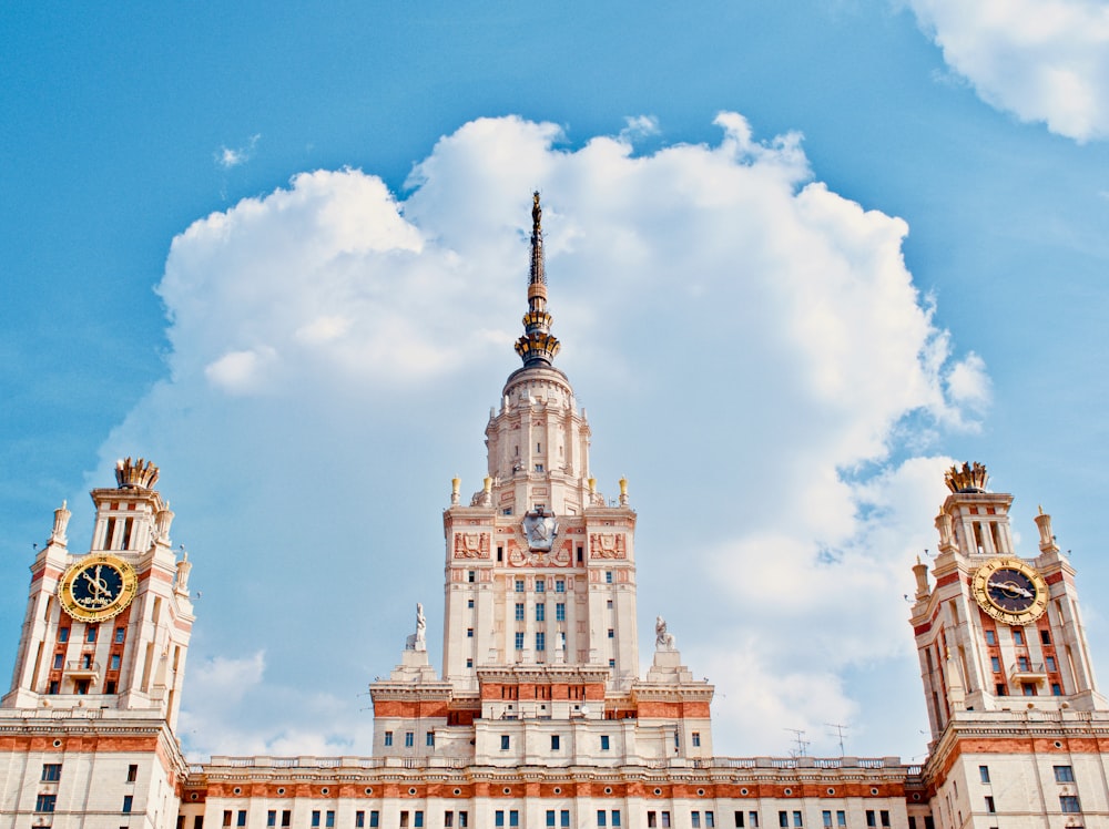 Weißes und braunes Betongebäude unter weißen Wolken während des Tages