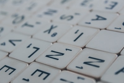 Close-up of colorful letter tiles arranged in a word search puzzle on a wooden table.