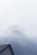 Professional repairing a roof leak with tools on a cloudy day