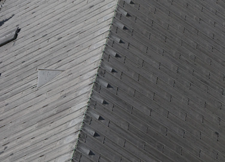 Close-up of a craftsman carefully applying protective treatment on a wooden roof.