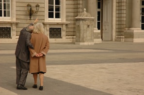 An elderly couple admiring ancient architecture during a tour.