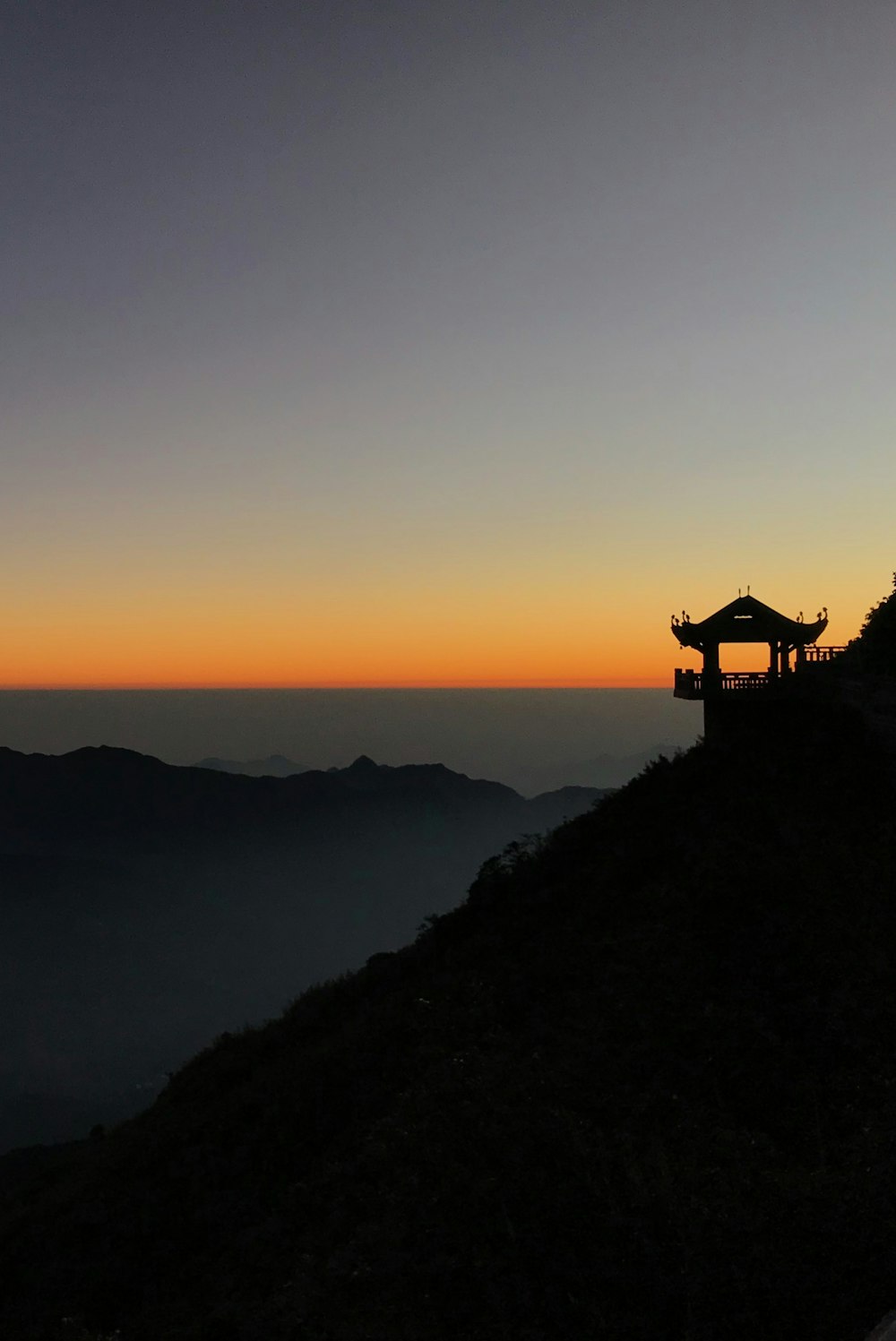 silhouette of tori building near mountain