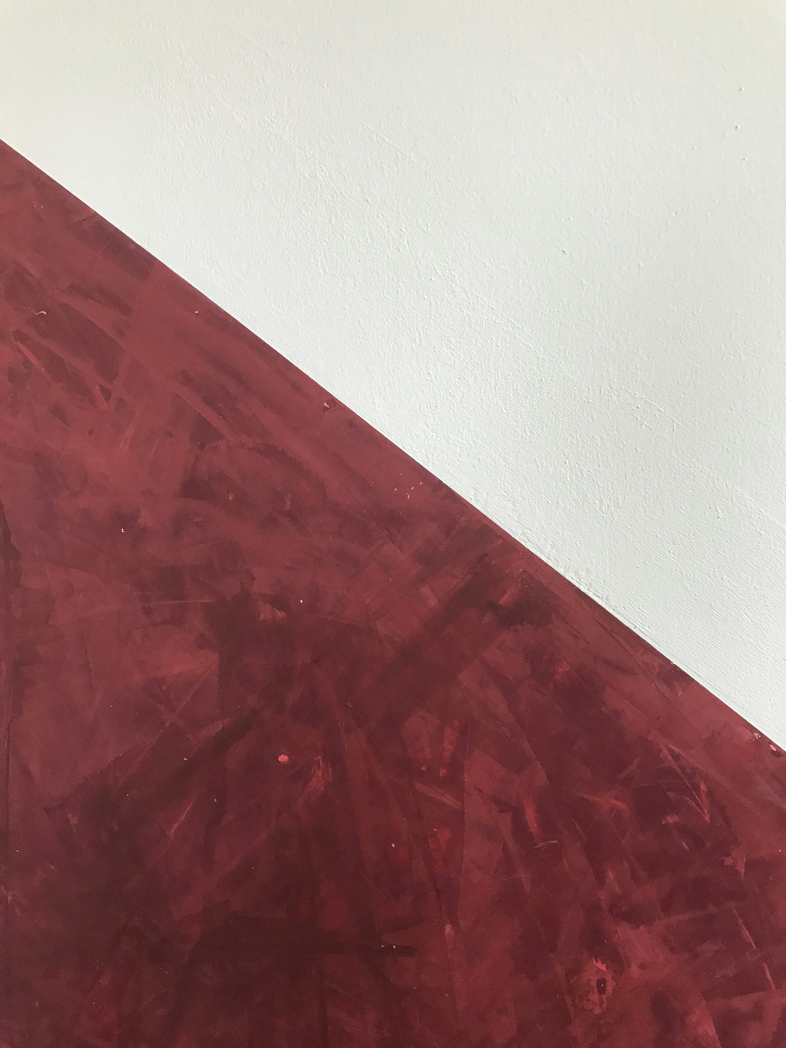 Un primo piano di un tavolo rosso con una parete bianca sullo sfondo