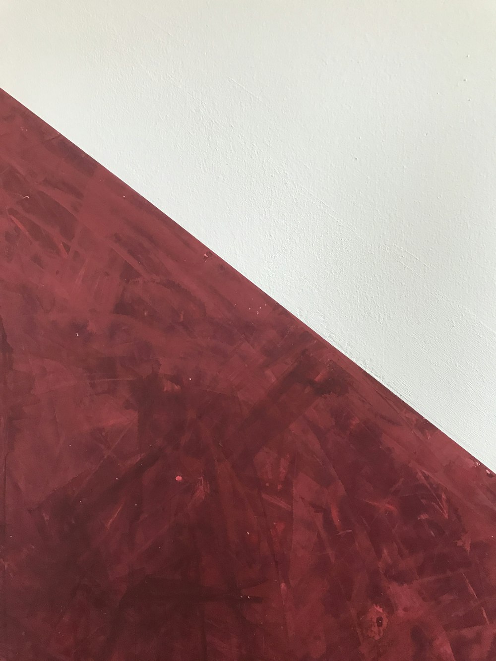 a close up of a red table with a white wall in the background