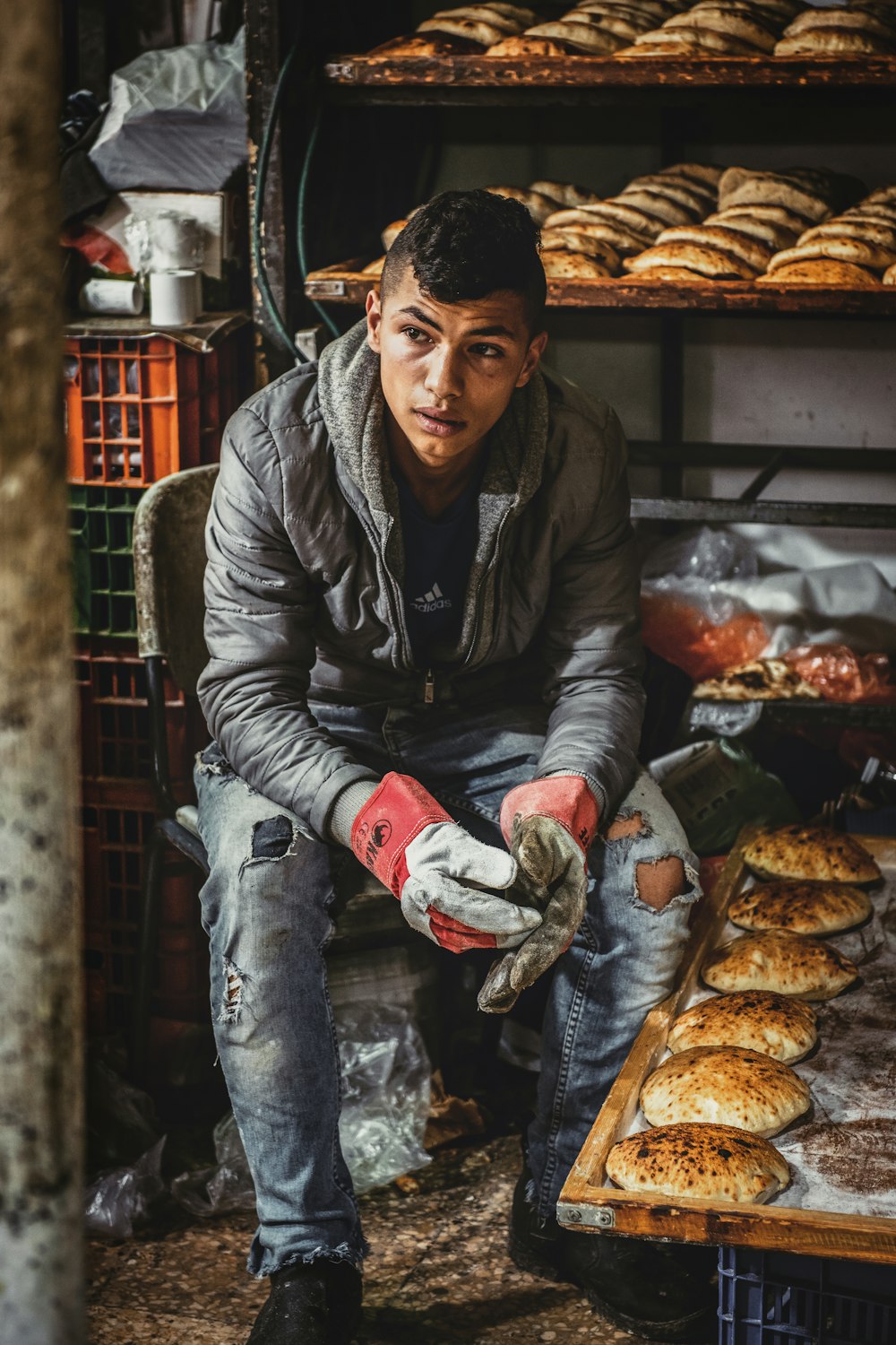 man sitting on chair near baked breads