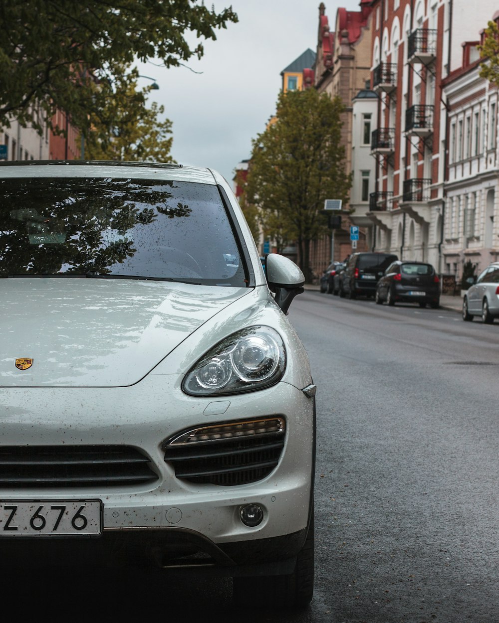 white Porsche SUV on sidewalk