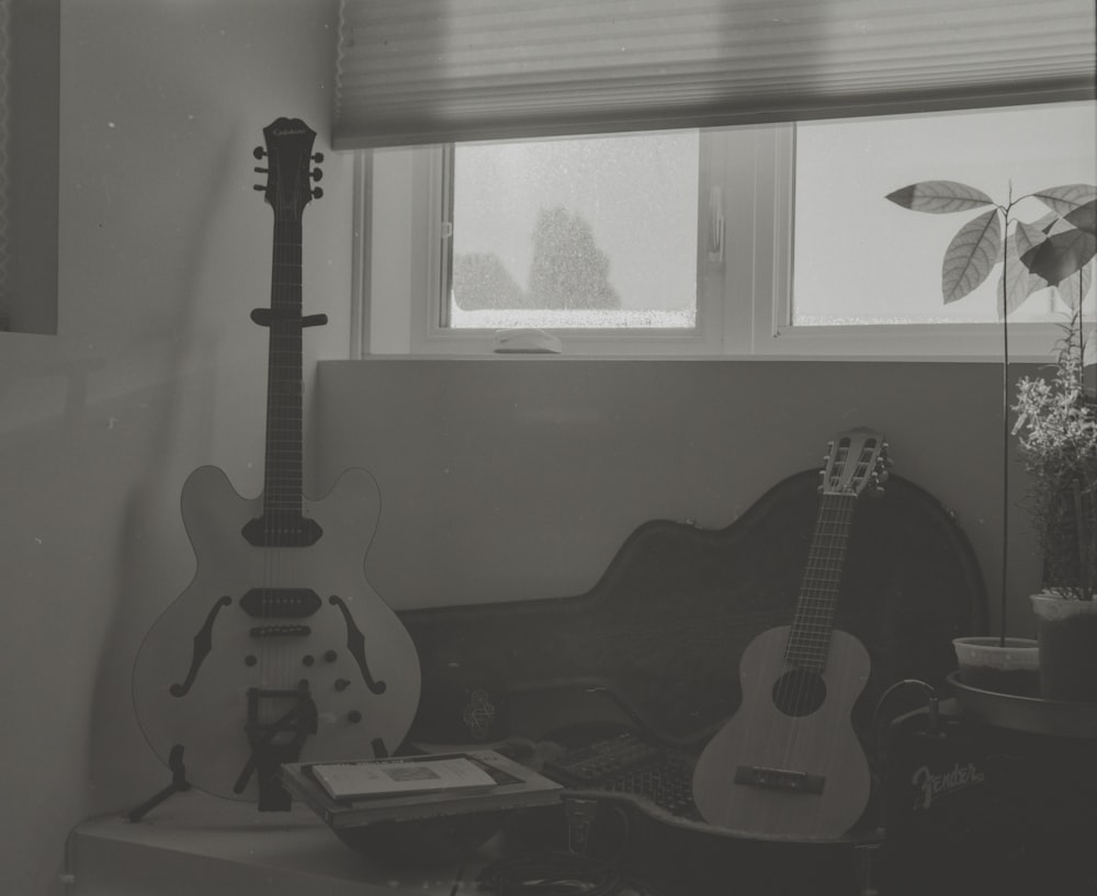 two guitars leaning on chairs and table inside room