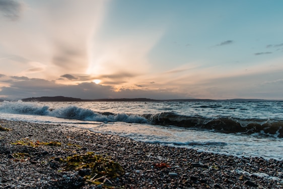 A serene island landscape with gentle waves and a warm sunset.