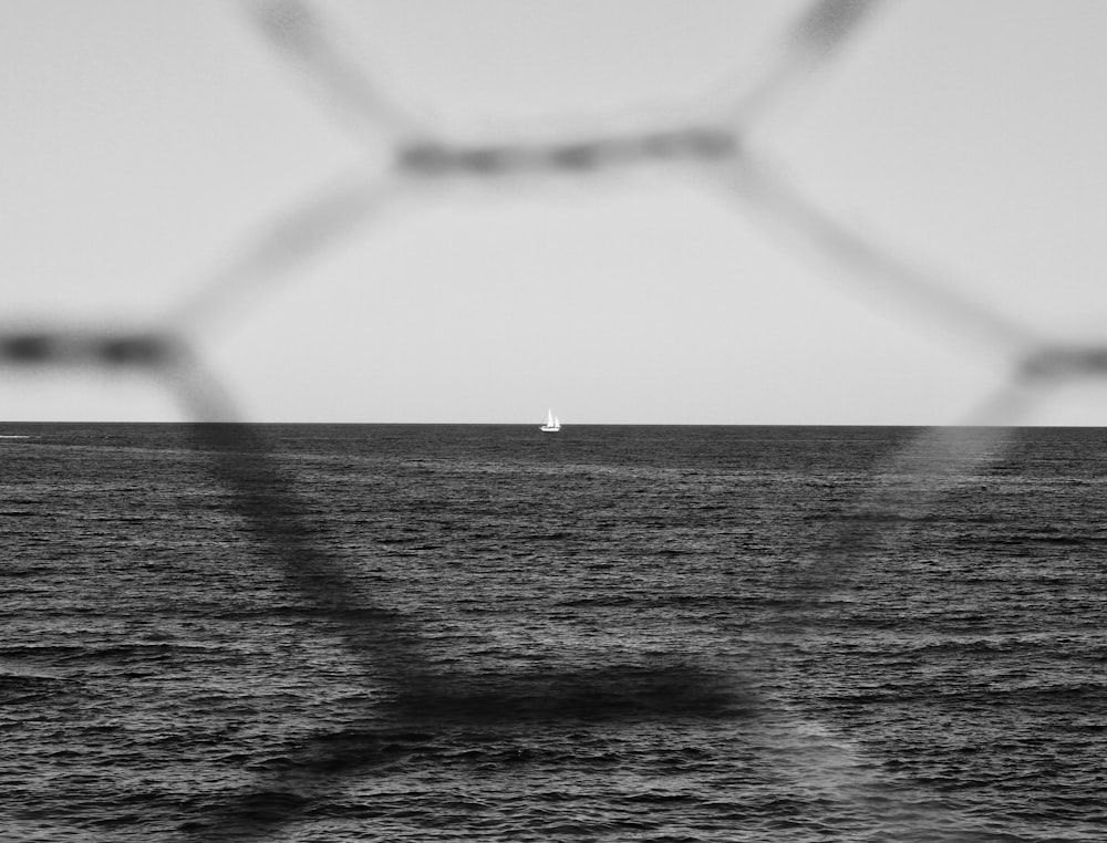 boat on ocean through chicken wire fence