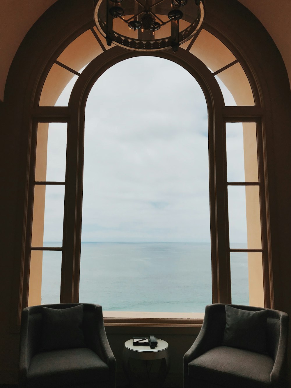 brown wooden framed window and grey padded chairs