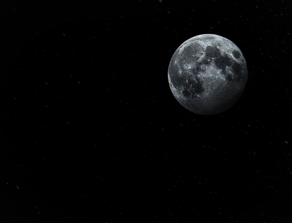 a full moon is seen in the dark sky