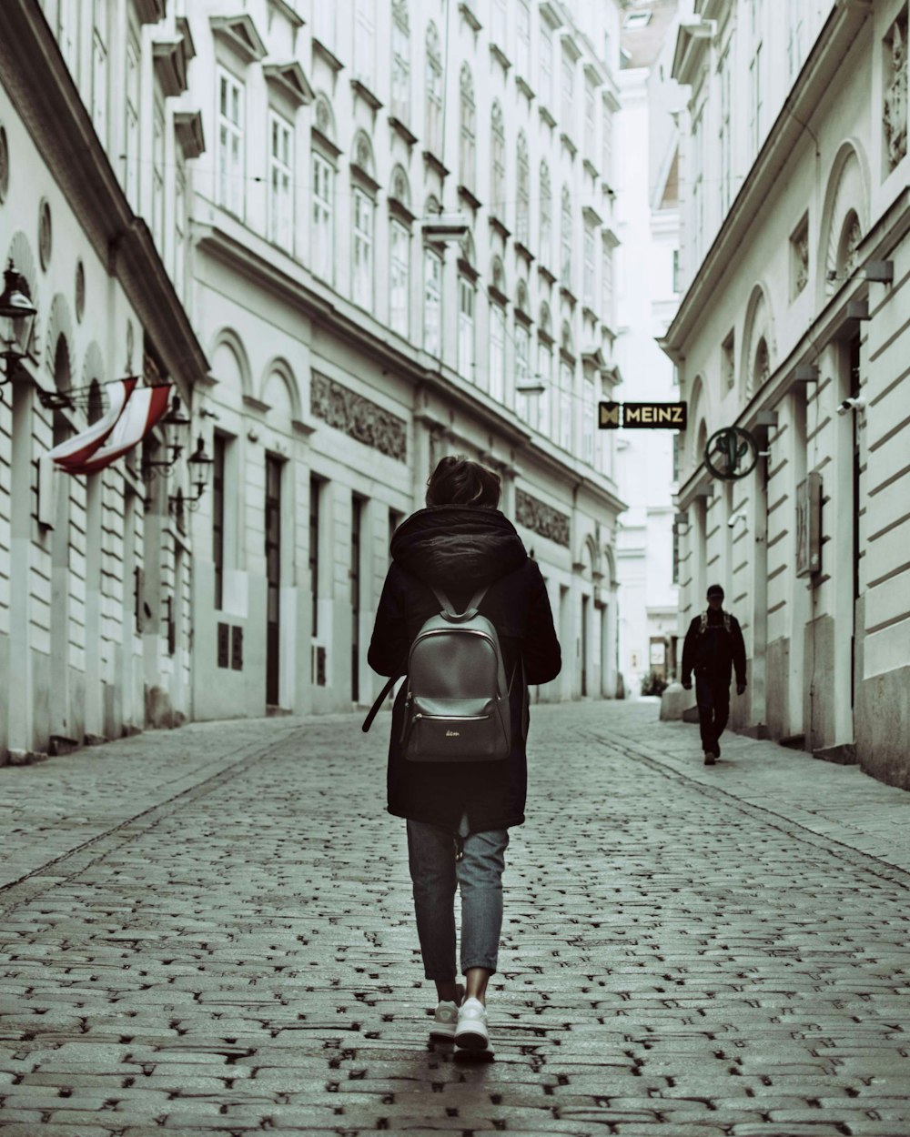 person walking on road near houses