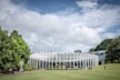 a large glass building sitting on top of a lush green field
